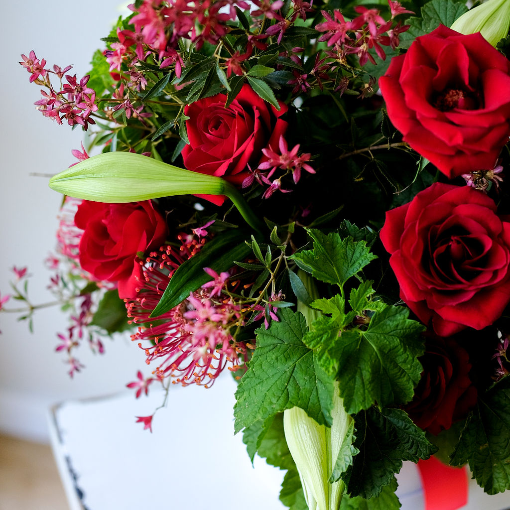 Celebrate Christmas with our Noel Hat Box Arrangement featuring lilies, holly, spruce & berries. Same day delivery available. Custom colours available.